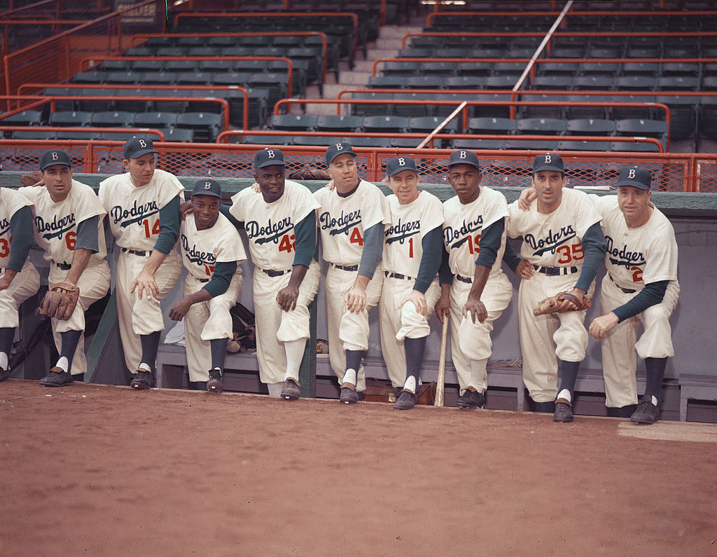 Portrait of members of the Brooklyn Dodgers baseball team pose in the dugout, 1954. From left, Americans Carl Furillo (1922 - 1989) (#6) and Gil Hodges (1924 - 1972) (#14), Cuban Sandy Amoros (1930 - 1992) (#15), and Americans Jackie Robinson (1919 - 1972) (#42), Duke Snider (#4), Pee Wee Reese (1918 - 1990) (#1), Jim Gilliam (1928 - 1978) (#19), Pete Wojey (1919 - 1991) (#35), and manager Walter Alston (1911 - 1984) (#24). (Photo by Hulton Archive/Getty Images)