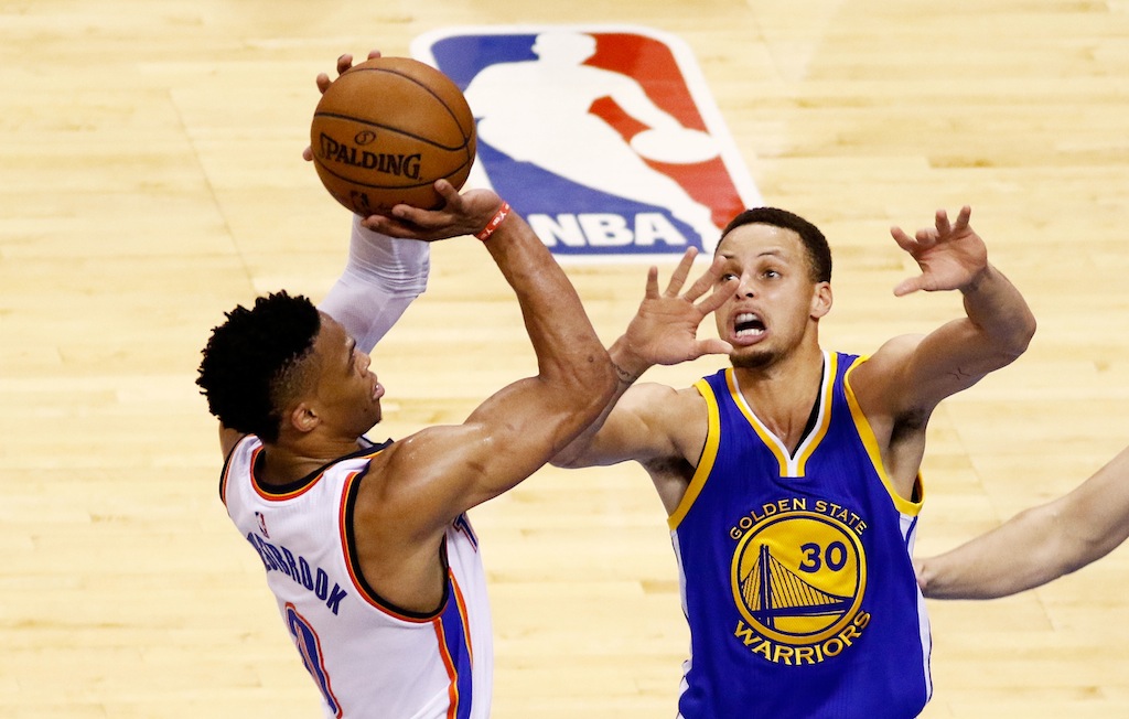 Steph Curry tries to block Russell Westbrook during a game.