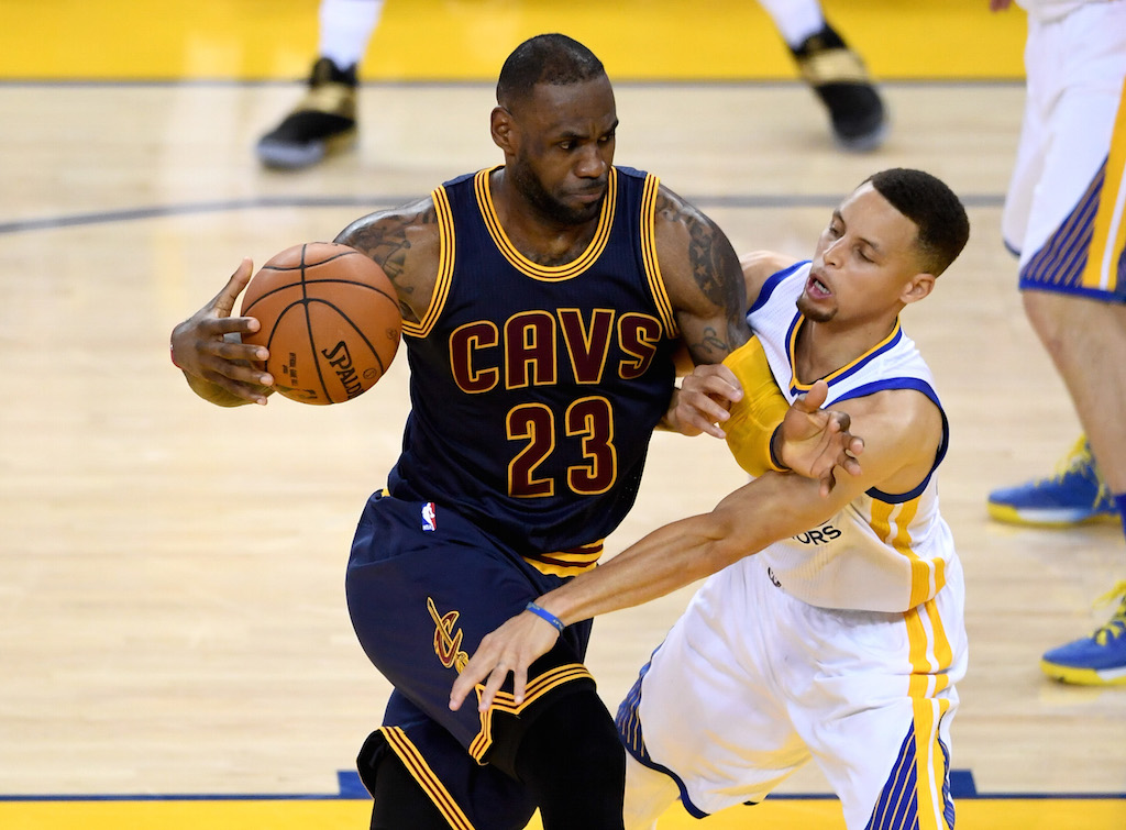 LeBron James looks to drive past Stephen Curry.