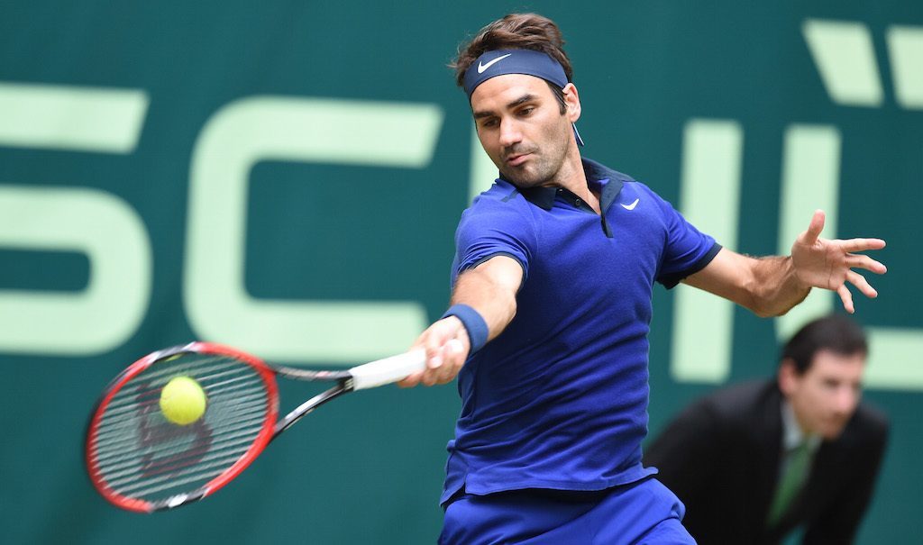 roger federer serving a forehand return in blue