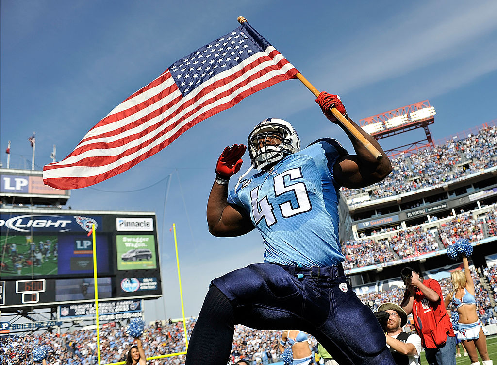 Armed services veteran Ahmard Hall (of the Tennessee Titans) brings out the American flag before a game.
