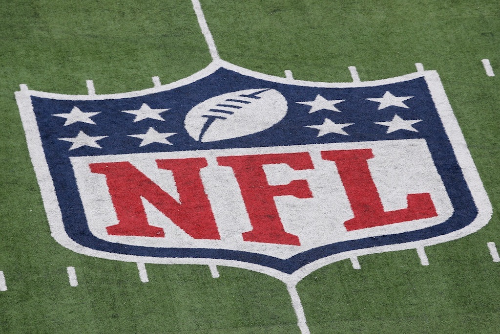 The NFL logo on the field. 