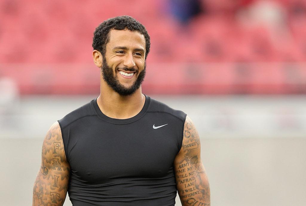 Colin Kaepernick smiles, wearing a black Nike tank top