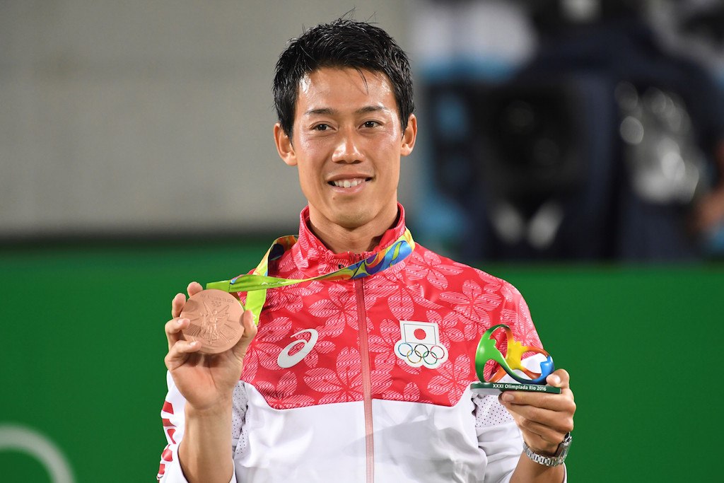 Kei Nishikori holding up his bronze metals.