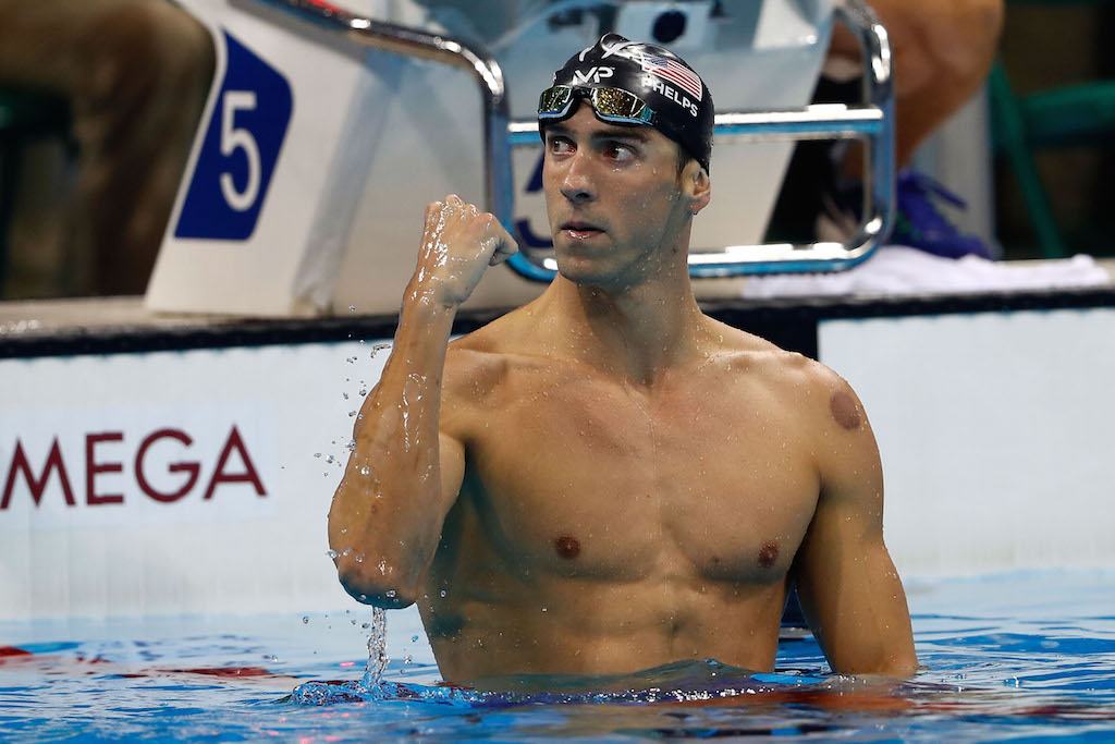 Michael Phelps fist pumps after winning a race.