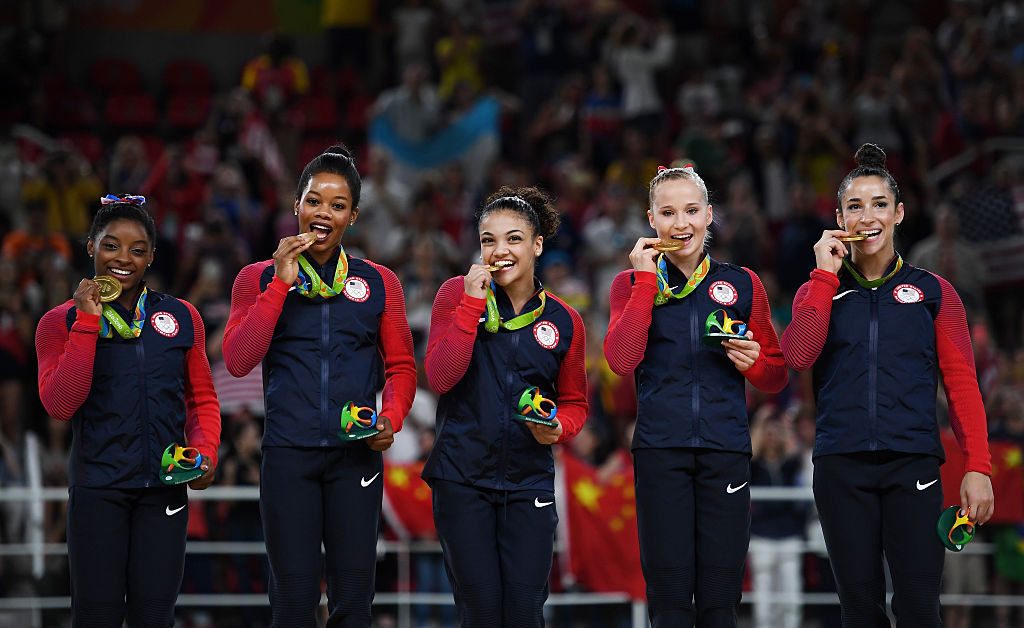 Gold Medalists Simone Biles, Gabrielle Douglas, Lauren Hernandez, Madison Kocian and Alexandra Raisman of the United States celebrate on the podium at the medal ceremony for the Artistic Gymnastics Women's Team.