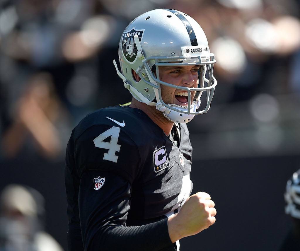 Derek Carr cheers and pumps his fist after throwing a touchdown pass.