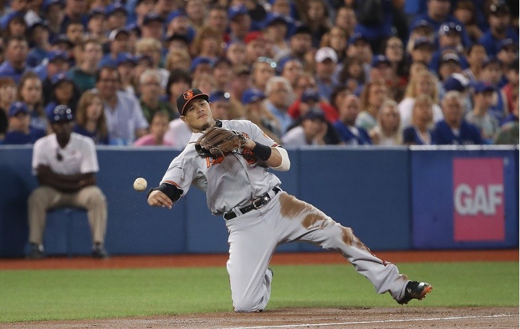 TORONTO, CANADA - JULY 31: Manny Machado #13 of the Baltimore Orioles cannot throw out Edwin Encarnacion #10 of the Toronto Blue Jays as he hits an infield single in the first inning during MLB game action on July 31, 2016 at Rogers Centre in Toronto, Ontario, Canada.