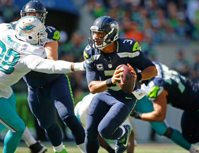 Russell Wilson tries to evade the Dolphins' rush.
