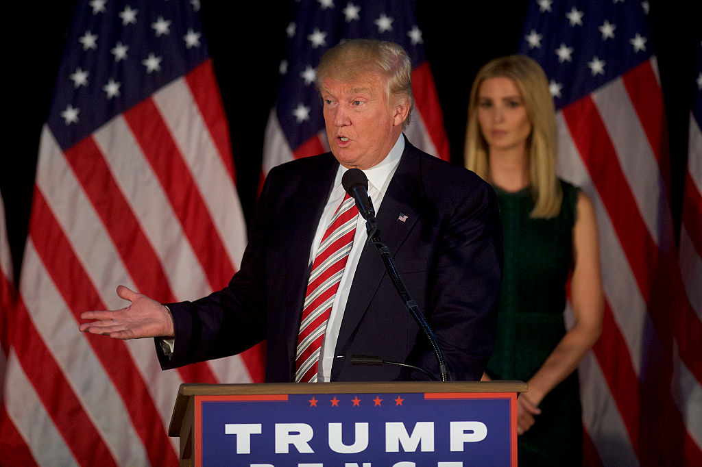 Donald Trump speaking while daughter Ivanka Trump stands behind him.