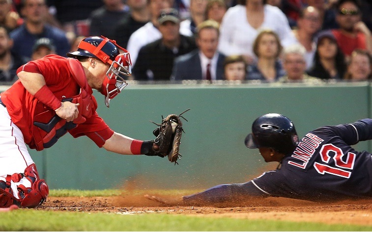 Francisco Lindor of the Cleveland Indians slides under the tag of Christian Vazquez of the Boston Red Sox during a 2016 game.