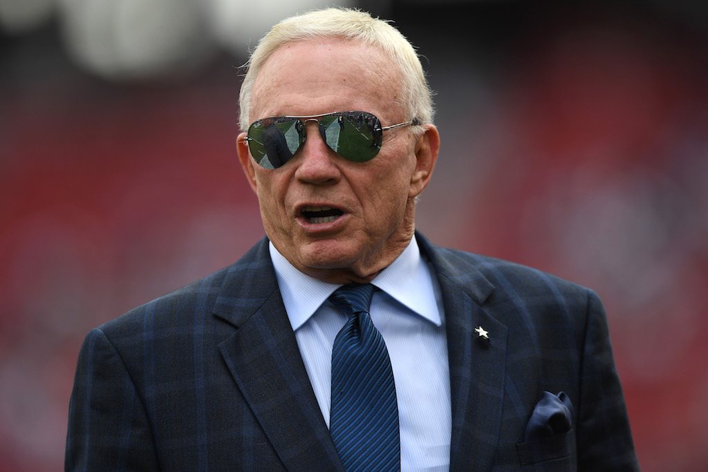 Jerry Jones talks as he stands on the sideline.
