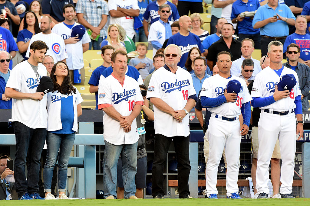 Ashton Kutcher and wife Mila Kunis stand with former Los Angeles Dodgers player Ron Cey