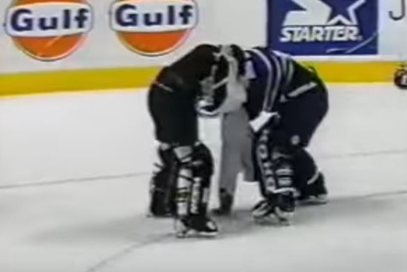 Two goalies from opposing hockey teams fighting during a game