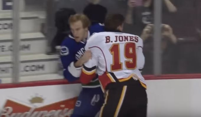 Two opposing players fight before a hockey game