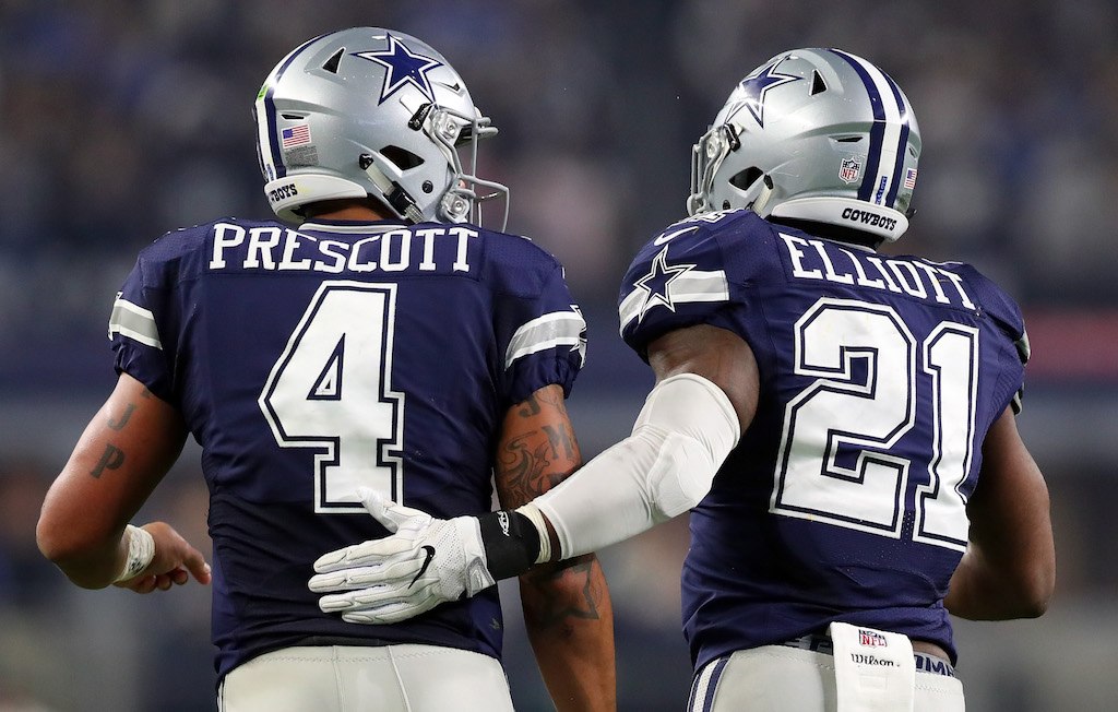 Dak prescott and Ezekiel Elliott pat each other on the back after winning a game.