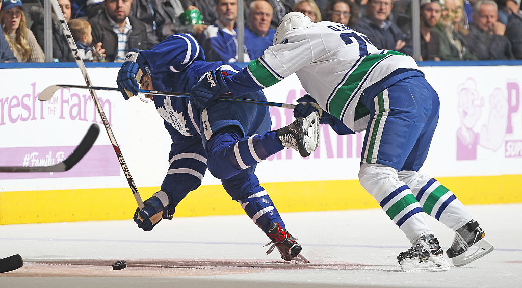 Daniel Sedin of the Vancouver Canucks knocks down Nazem Kadri of the Toronto Maple Leafs | Claus Andersen/Getty Images