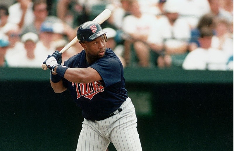 American professional baseball player Kirby Puckett (1960 - 2006) of the Minnesota Twins begins to swing at a pitch during an away game, late 20th Century. Puckett played for the Twins from 1984 to 1996, the entirety of his professional career.