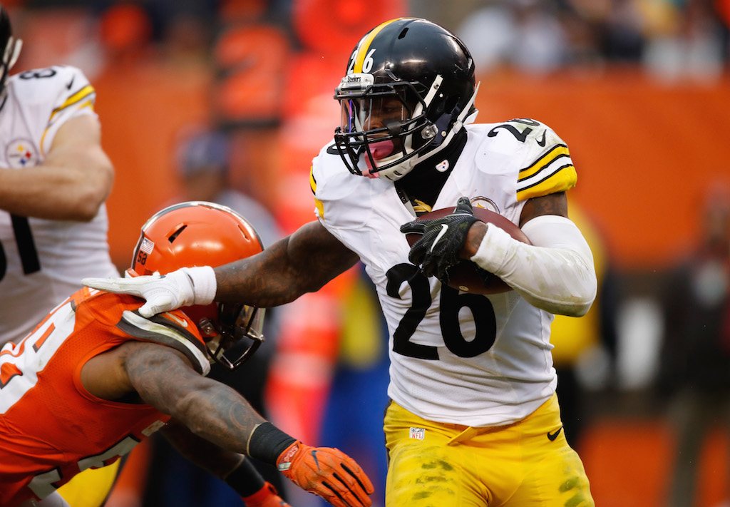 Le'Veon Bell pushes past a defender.
