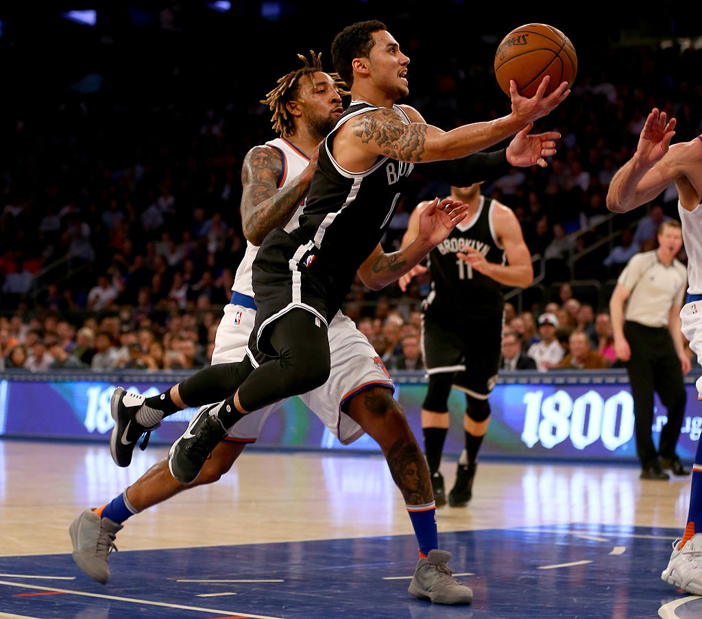Shane Larkin #0 of the Brooklyn Nets heads for the net as Derrick Williams #23 of the New York Knicks tries to block him