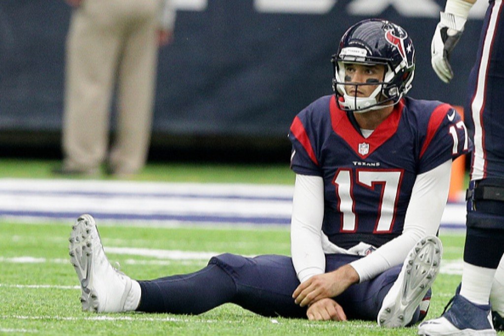 Brock Osweiler of the Houston Texans sits on the field after being tripped up by Joey Bosa of the San Diego Chargers | Bob Levey/Getty Images
