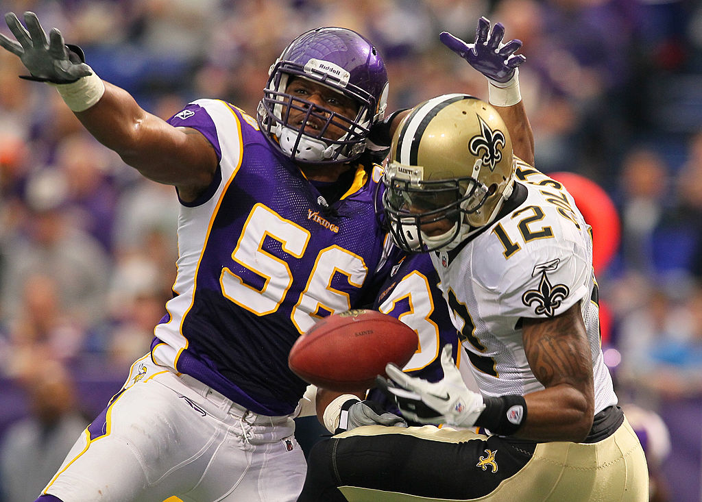 E.J. Henderson of the Minnesota Vikings attempts to disrupt the pass to Marques Colston of the New Orleans Saints.