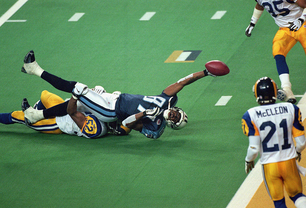 Kevin Dyson of the Tennessee Titans reaches for the end zone with the ball as Mike Jones of the St. Louis Rams tackles him.