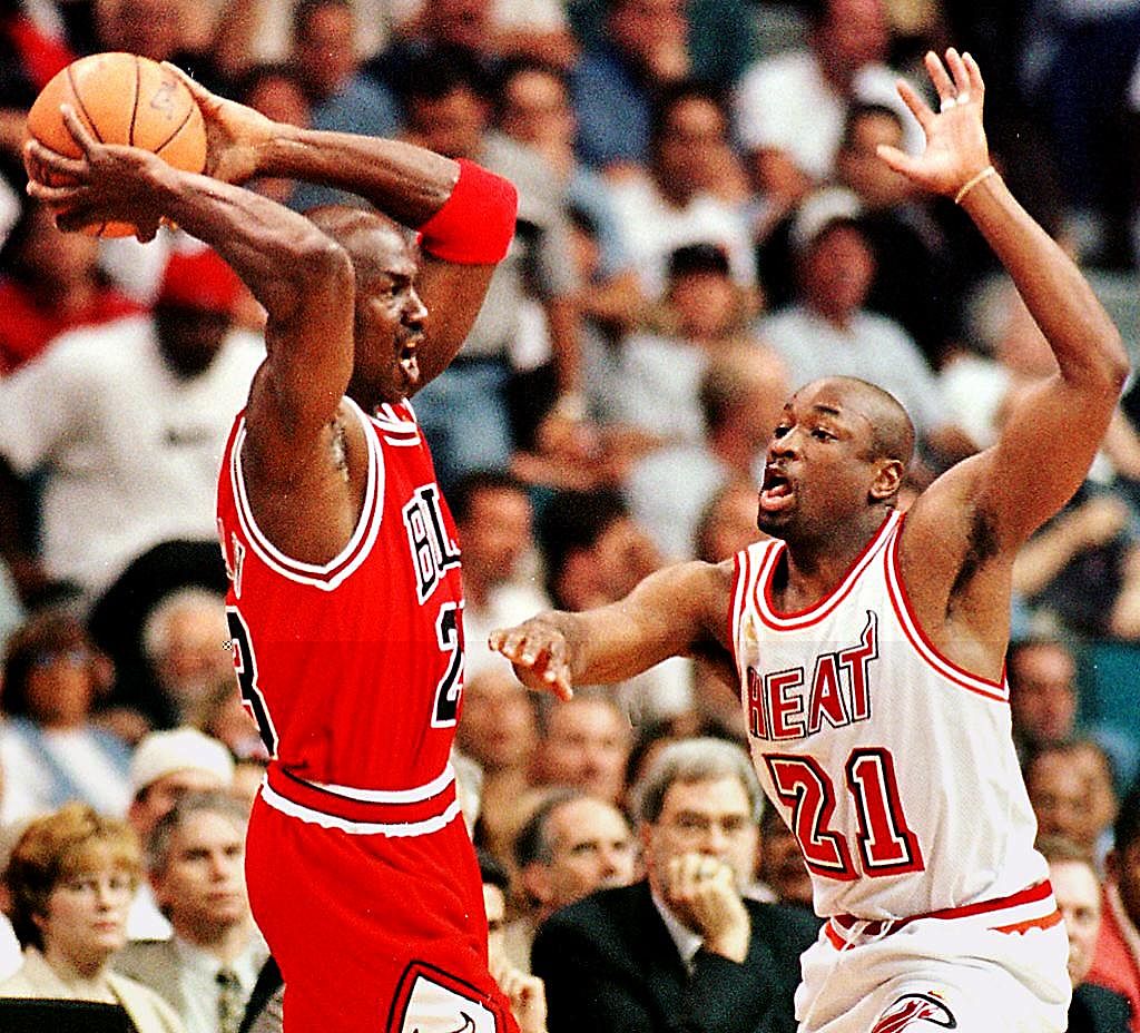 Michael Jordan of the Chicago Bulls handles the ball as Voshon Lenard of the Miami Heat struggles to keep him covered.