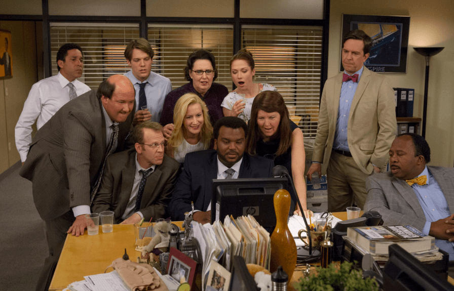 the office employees gathered around a computer Office, employees, co-workers, computer