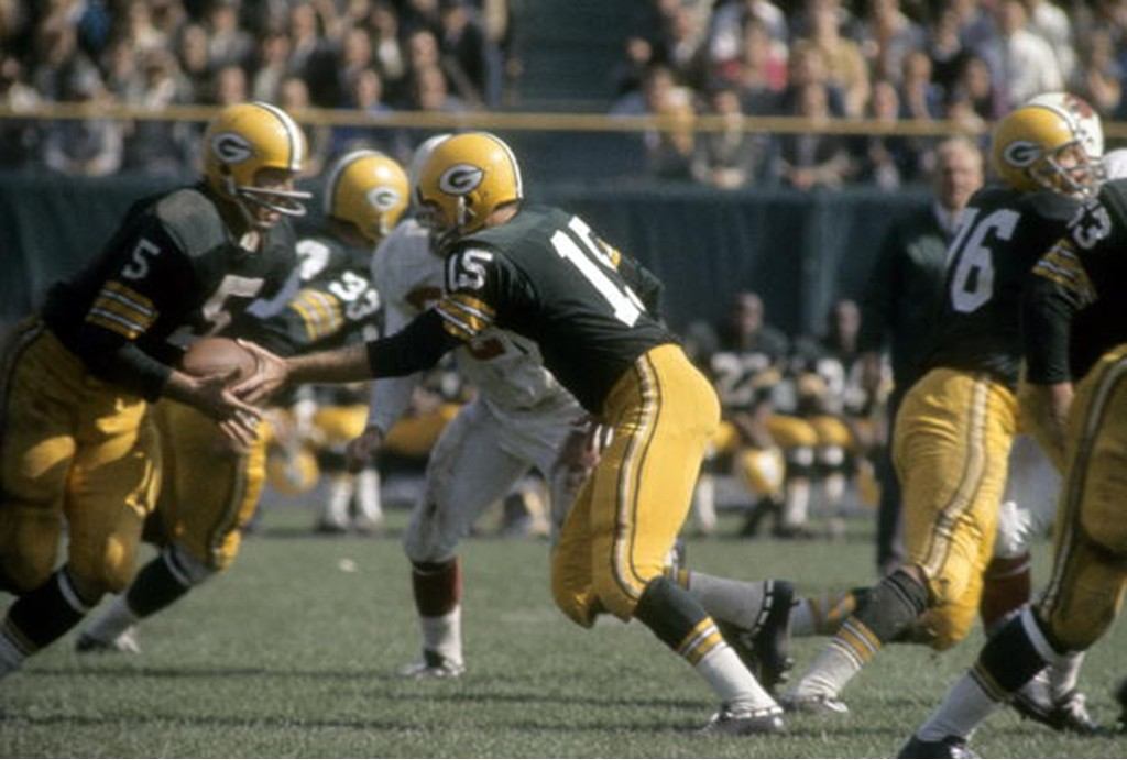 Running back Paul Hornung of the Green Bay Packers takes the hand off from quarterback Bart Starr.