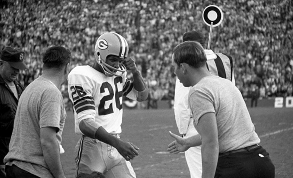 Defensive back Herb Adderley of the Green Bay Packers is congratulated as he returns to the sidelines after returning an interception 60 yards for a touchdown.
