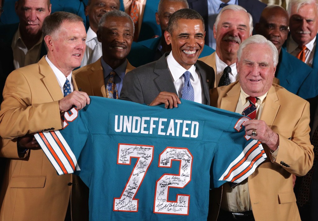 Former President Barack Obama poses for photos with the 1972 Miami Dolphins including head coach Don Shula, quarterback Bob Griese, and running back Larry Csonka.