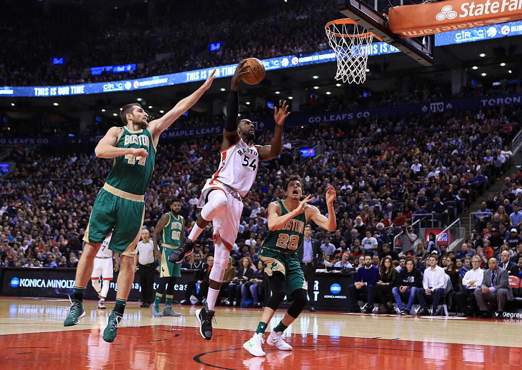 Patrick Patterson of the Toronto Raptors shoots the ball as Tyler Zeller of the Boston Celtics defends.
