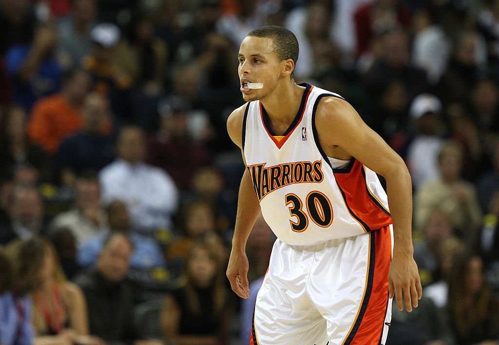 Stephen Curry bites on his mouthguard as he waits for a game to begin.