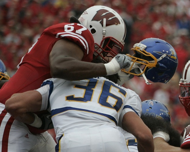 Wisconsin's Josh Oglesby rips the helmut off San Jose State's Vince Buhagiar.