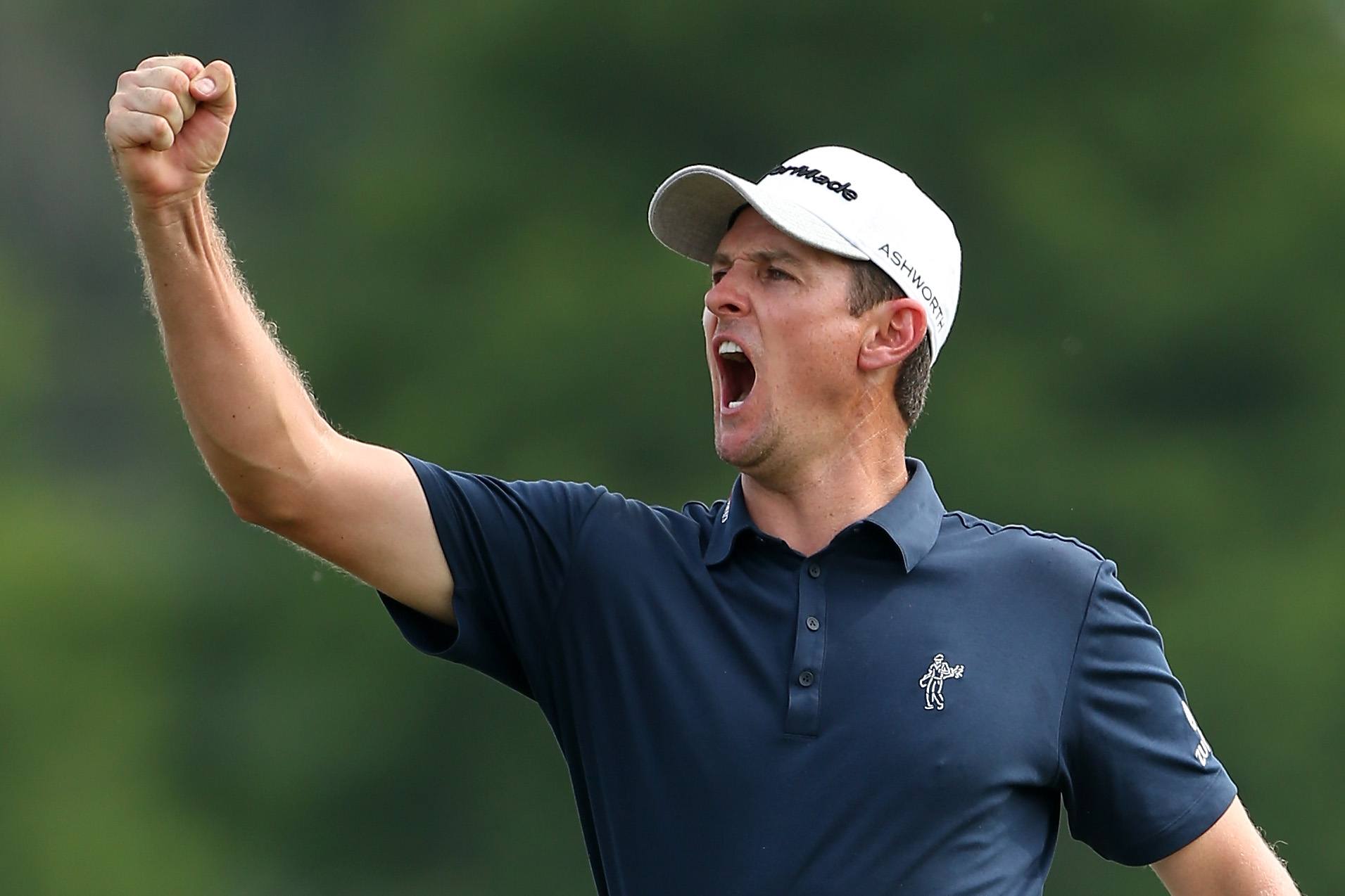 Justin Rose pumps his fist after getting a hole in one.