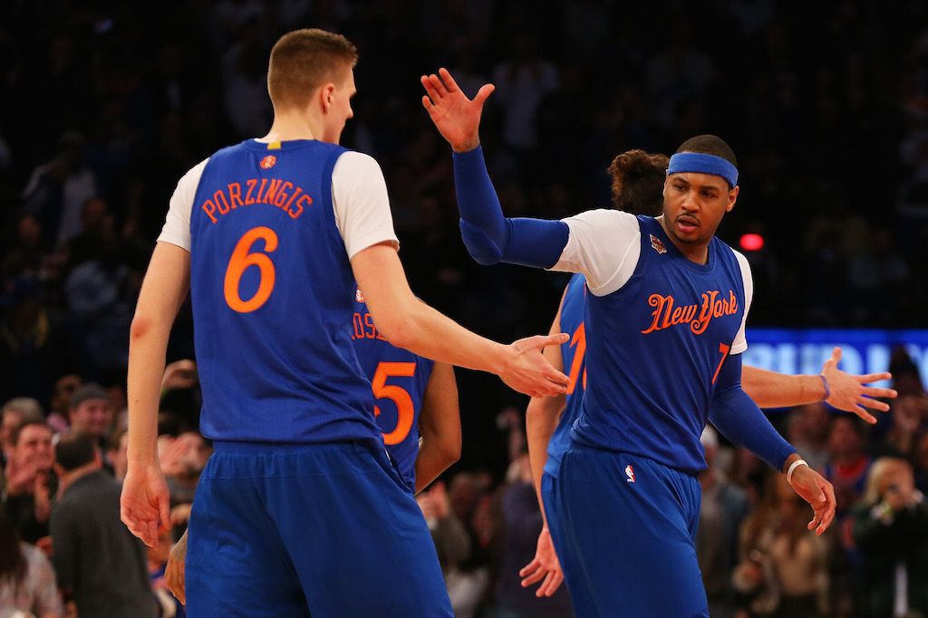 Kristaps Porzingis and Melo high five after scoring.