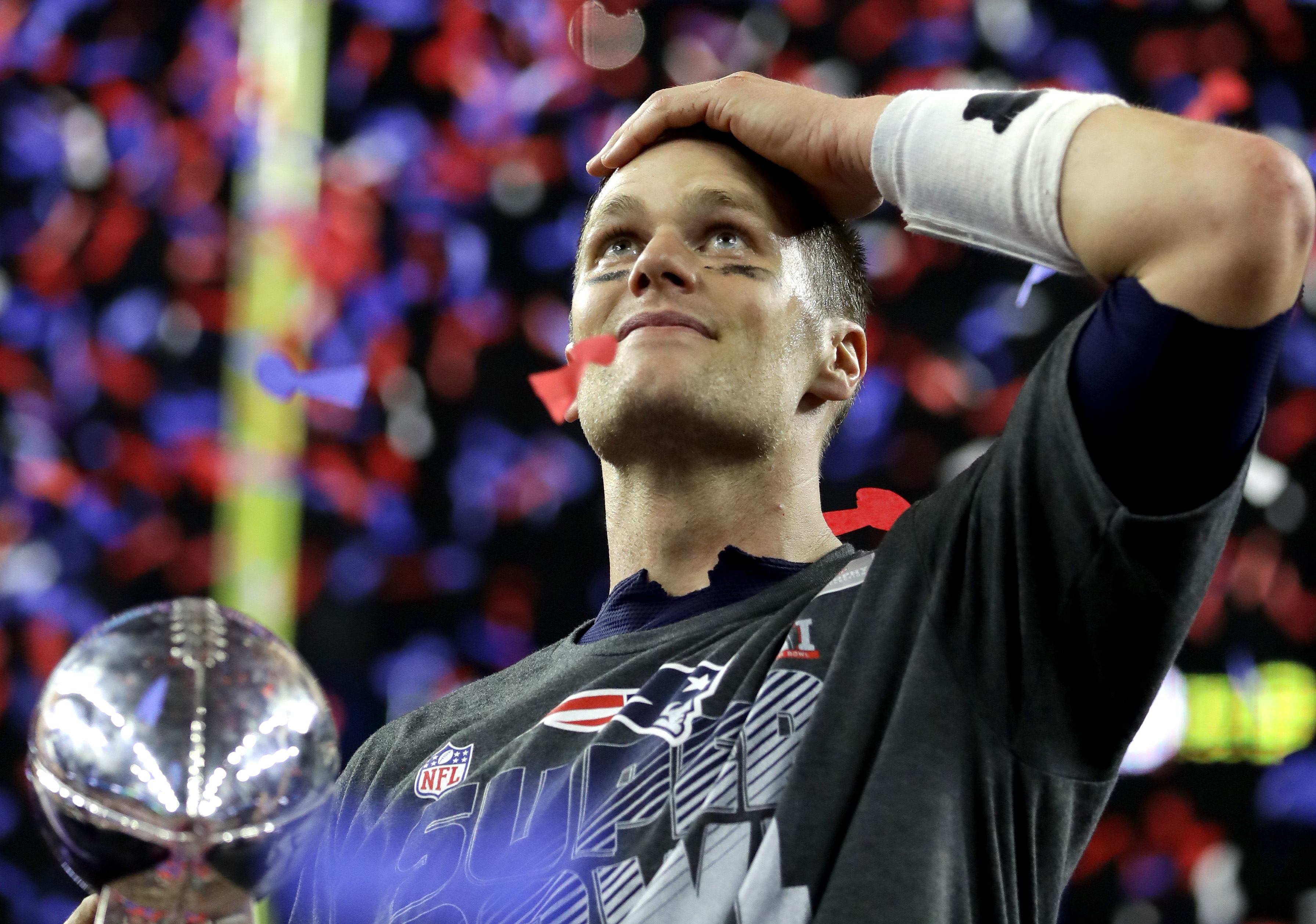 Tom Brady holds the Lombardi Trophy and looks out at the crowd | Ronald Martinez/Getty Images