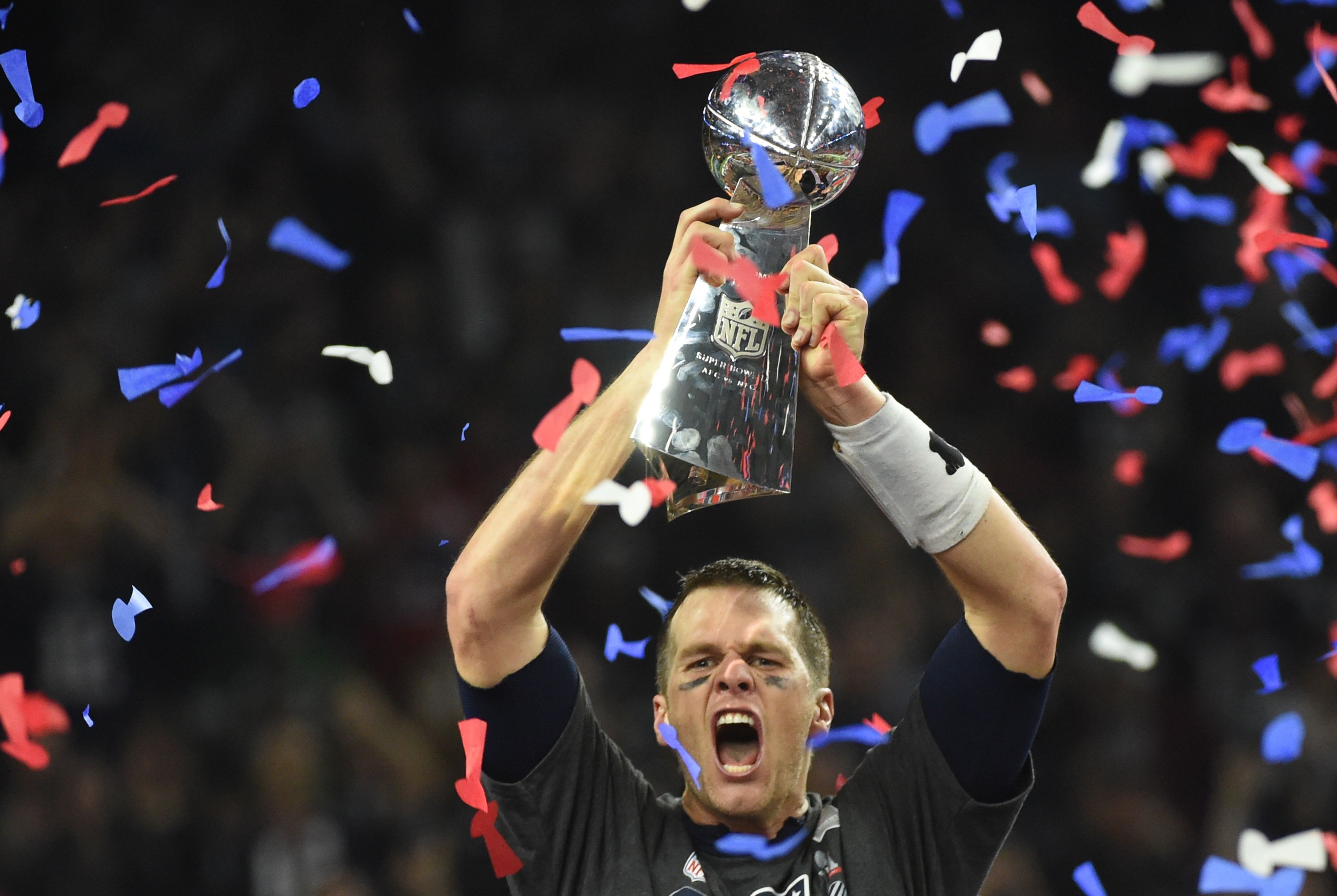 Tom Brady lifts the Lombardi Trophy into the air after winning Super Bowl 51.