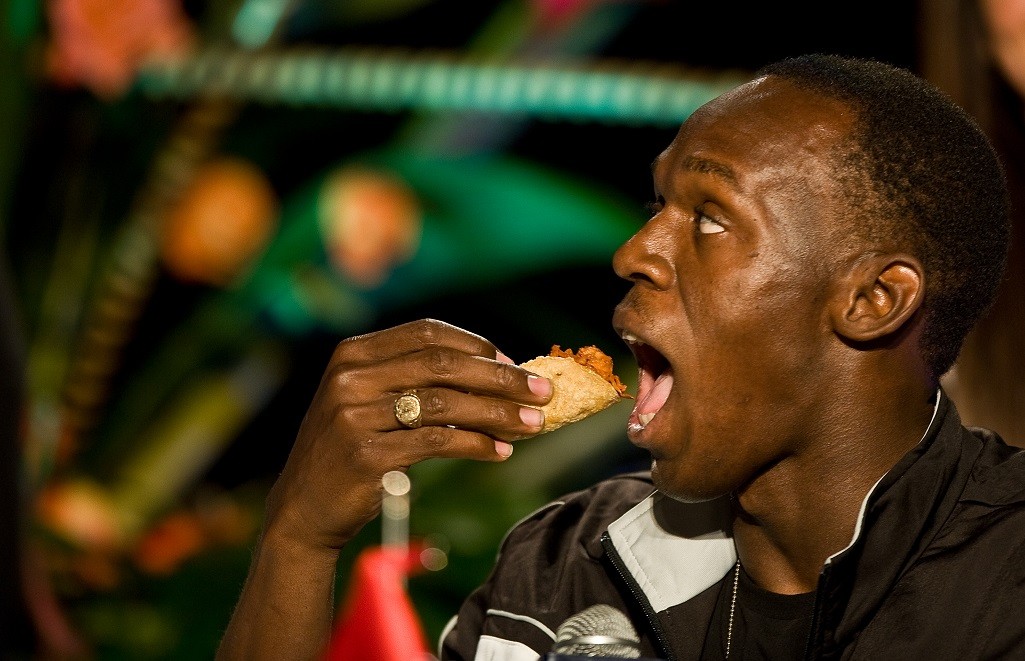 World and Olympic sprint champion Jamaican Usain Bolt eats a Mexican "Taco" during a conference at the World Sport Congress in Mexico City.