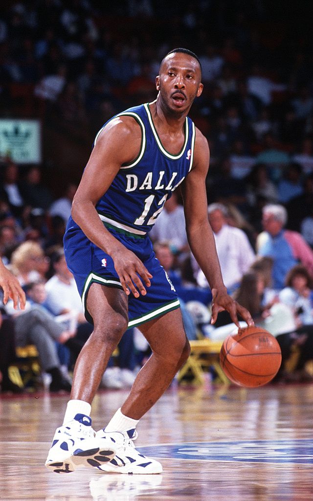 Le garde Derek Harper des Dallas Mavericks dribble le ballon en amont du terrain lors d'un match contre les Denver Nuggets.