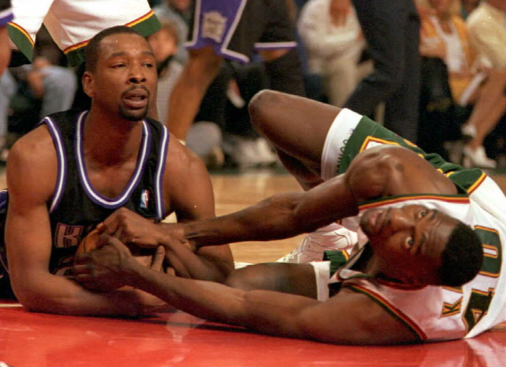 Seattle Supersonics Shawn Kemp and Lionel Simmons of the Sacramento Kings fight for the ball.