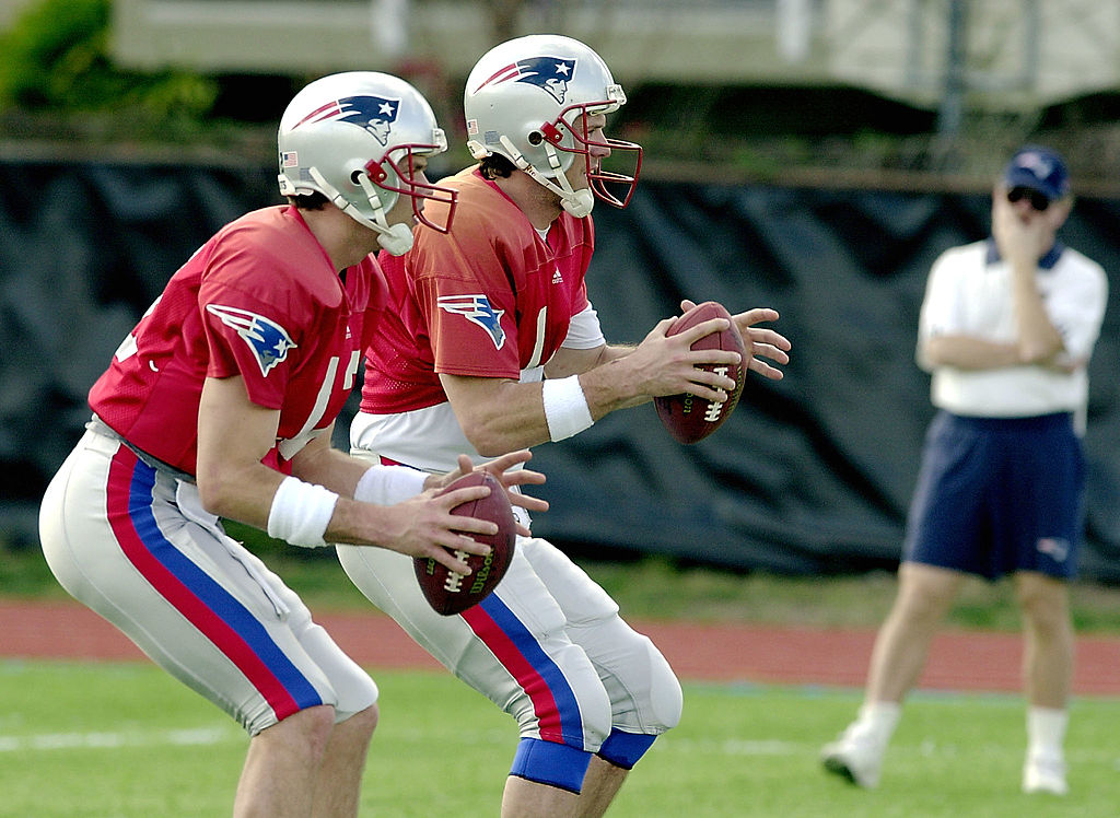 New England Patriots' quarterbacks Drew Bledsoe and Tom Brady run drills side-by-side. | Roberto Schmidt/AFP/Getty Images