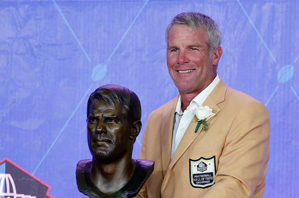 Brett Favre, former NFL quarterback, poses with his bronze bust during the NFL Hall of Fame Enshrinement Ceremony.