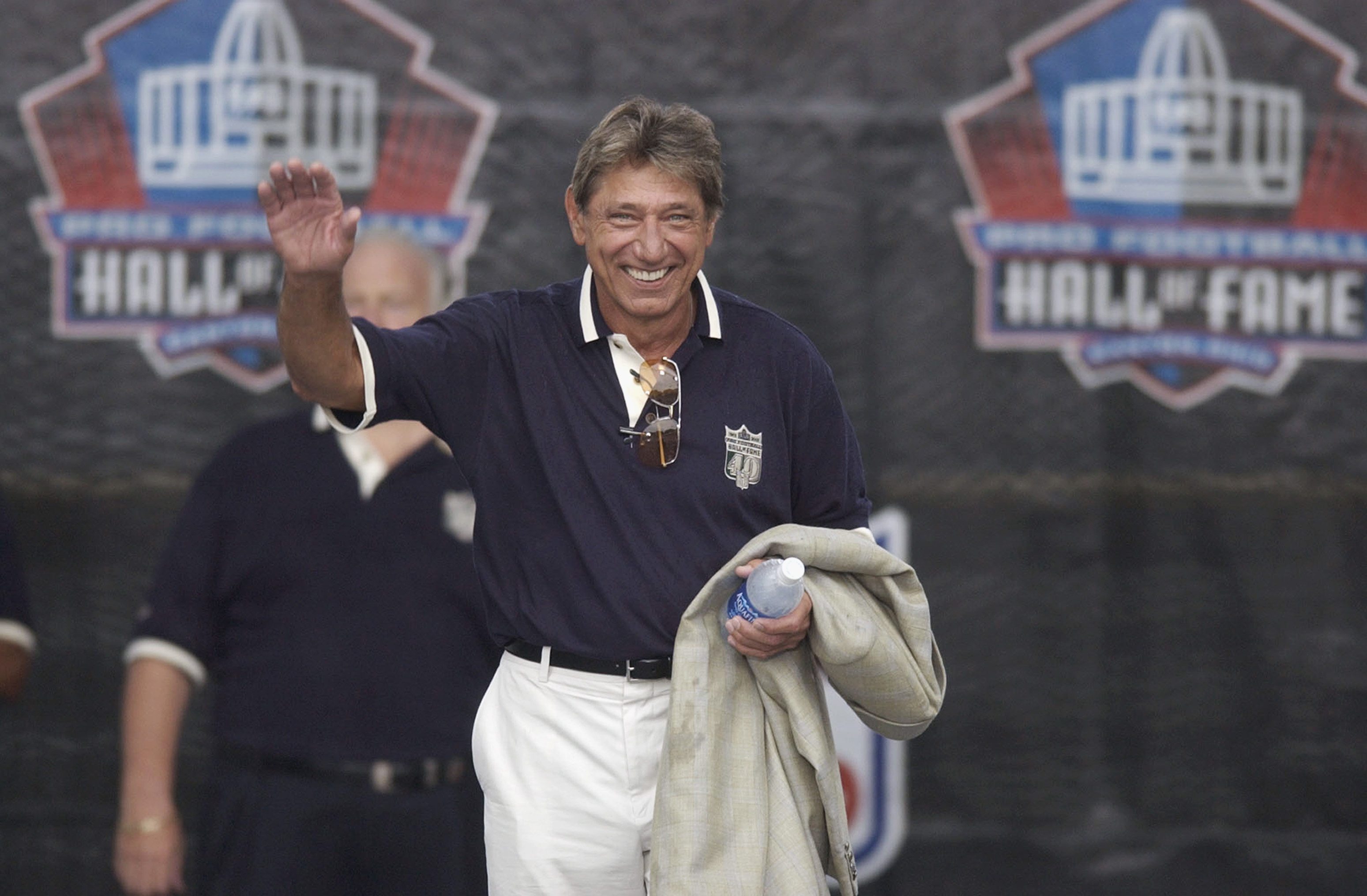 Joe Namath waves to the crowd during a Hall of Fame ceremony.