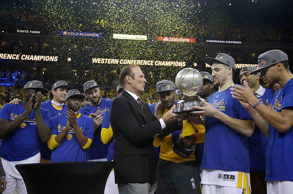 Klay Thompson #11 van de Golden State Warriors krijgt de Western Conference Championship Trophy overhandigd door voormalig NBA-speler Rick Barry na het verslaan van de Oklahoma City Thunder in Game Seven van de Western Conference Finals tijdens de 2016 NBA Playoffs in ORACLE Arena op 30 mei 2016 in Oakland, Californië. | Pool/Getty Images