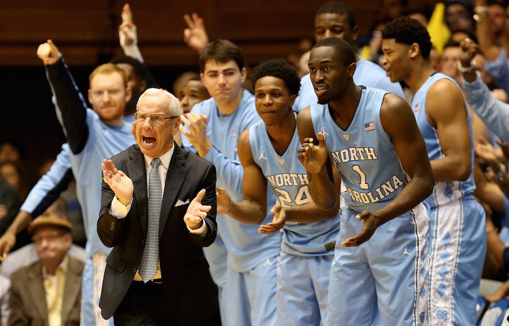 Roy Williams and some of his best UNC basketball players cheer for their team.