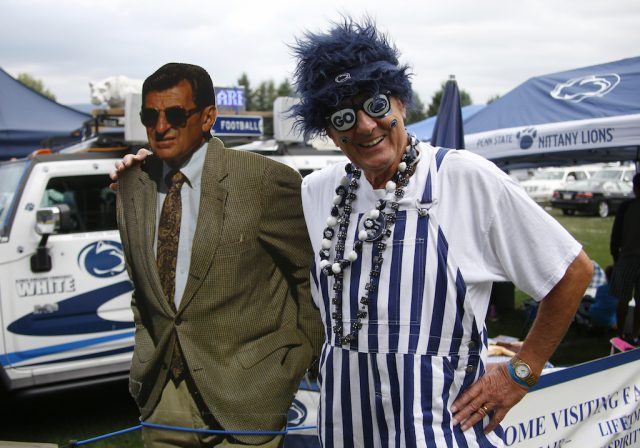 A Penn State fan stands with a Joe Paterno cutout.