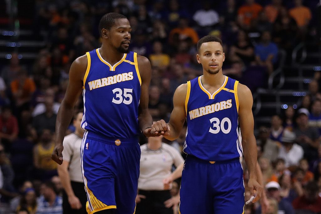 Kevin Durant and Stephen Curry chat on the court.