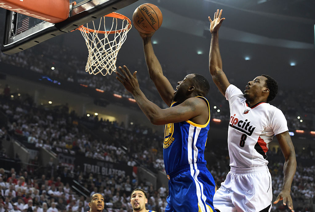 Draymond Green of the Golden State Warriors drive to the basket on Al-Farouq Aminu of the Portland Trail Blazers.